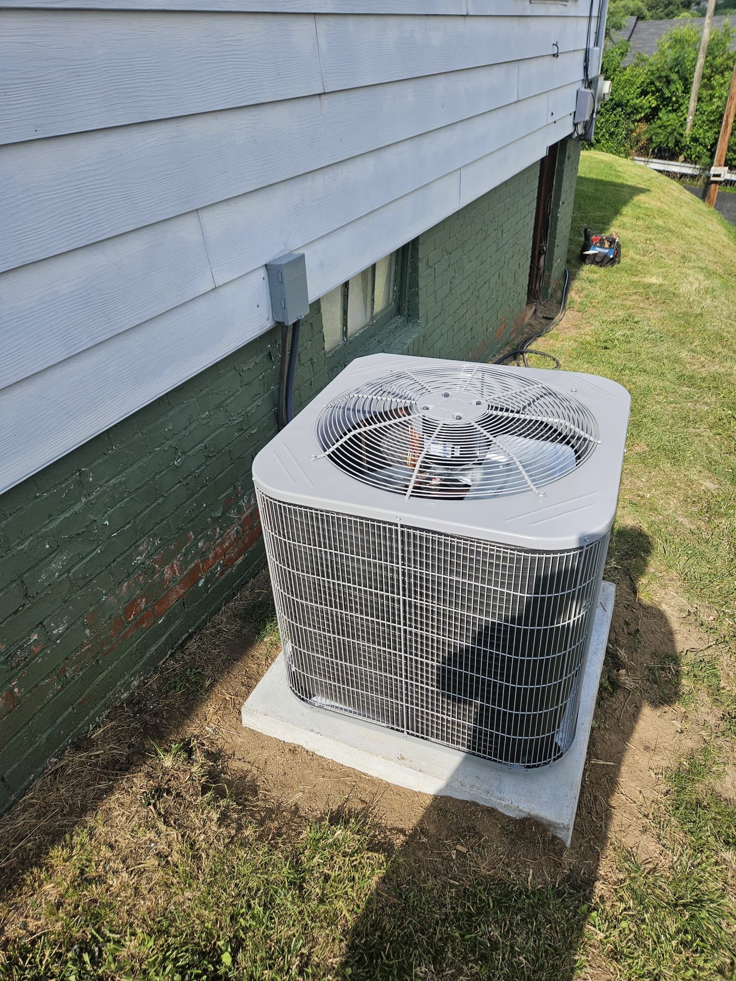 Completed installation of an outdoor HVAC unit on a sturdy concrete pad ensuring long-term stability