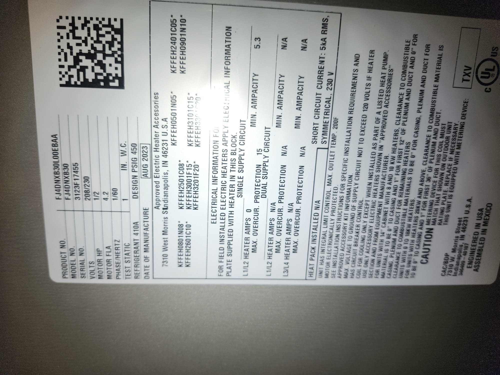 Clear data label on a newly installed HVAC unit showing model and electrical information