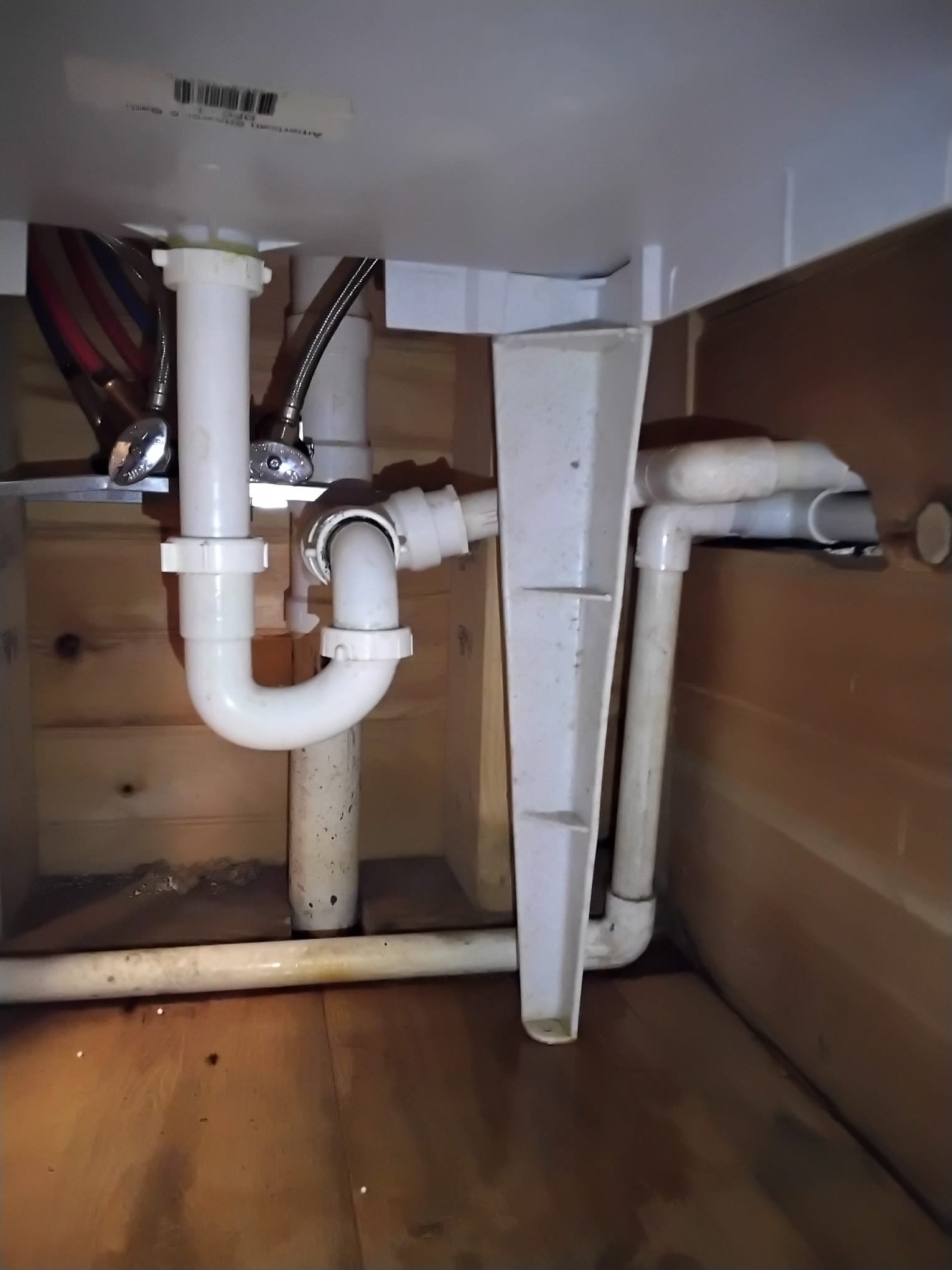 Newly installed plumbing setup under a sink