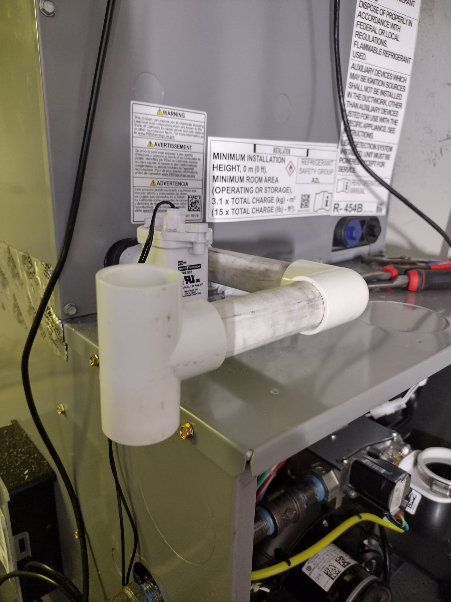 Condensate drain line with safety float switch installed next to the furnace.