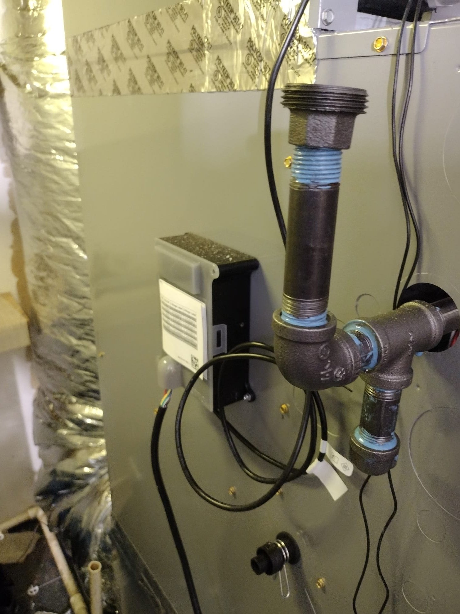 Freshly connected refrigerant and electrical lines on the outdoor unit.