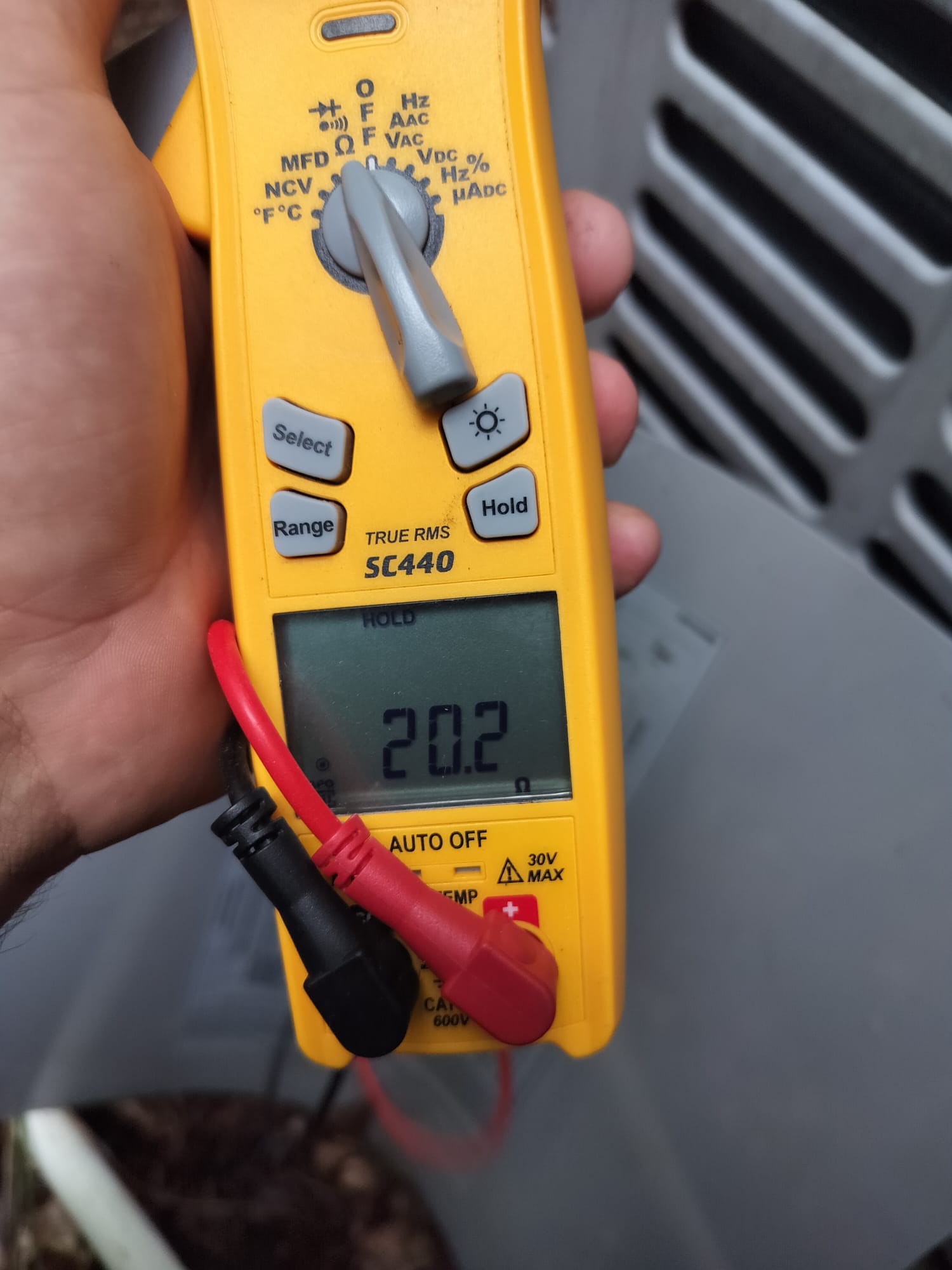 Technician verifying system amperage with a clamp meter