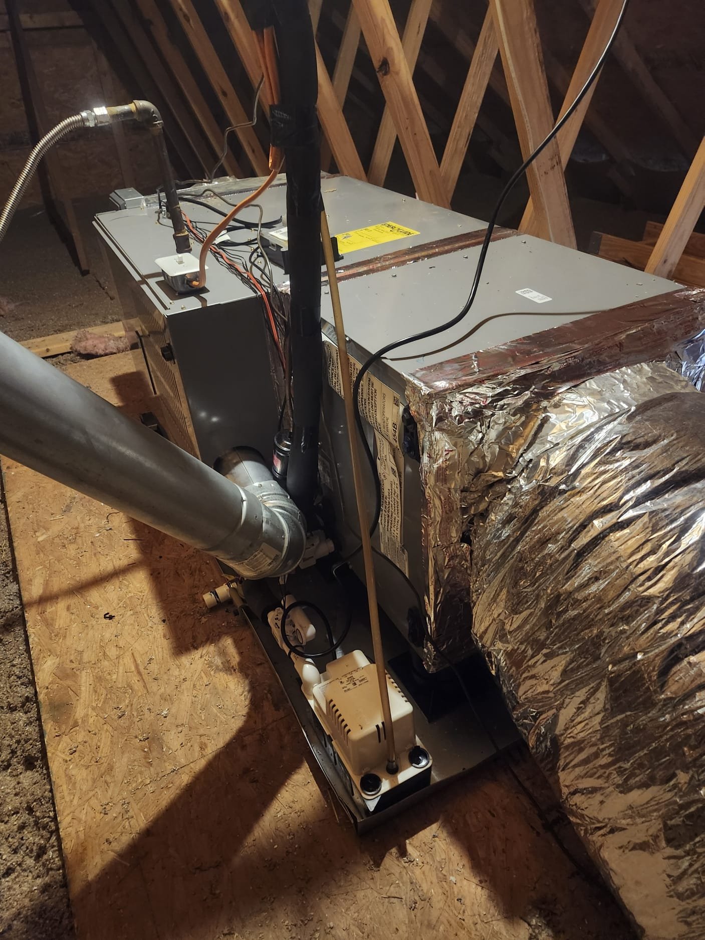 The new attic air handler with insulated ductwork and a clean condensate pump, ensuring efficient operation in the home’s upper space.