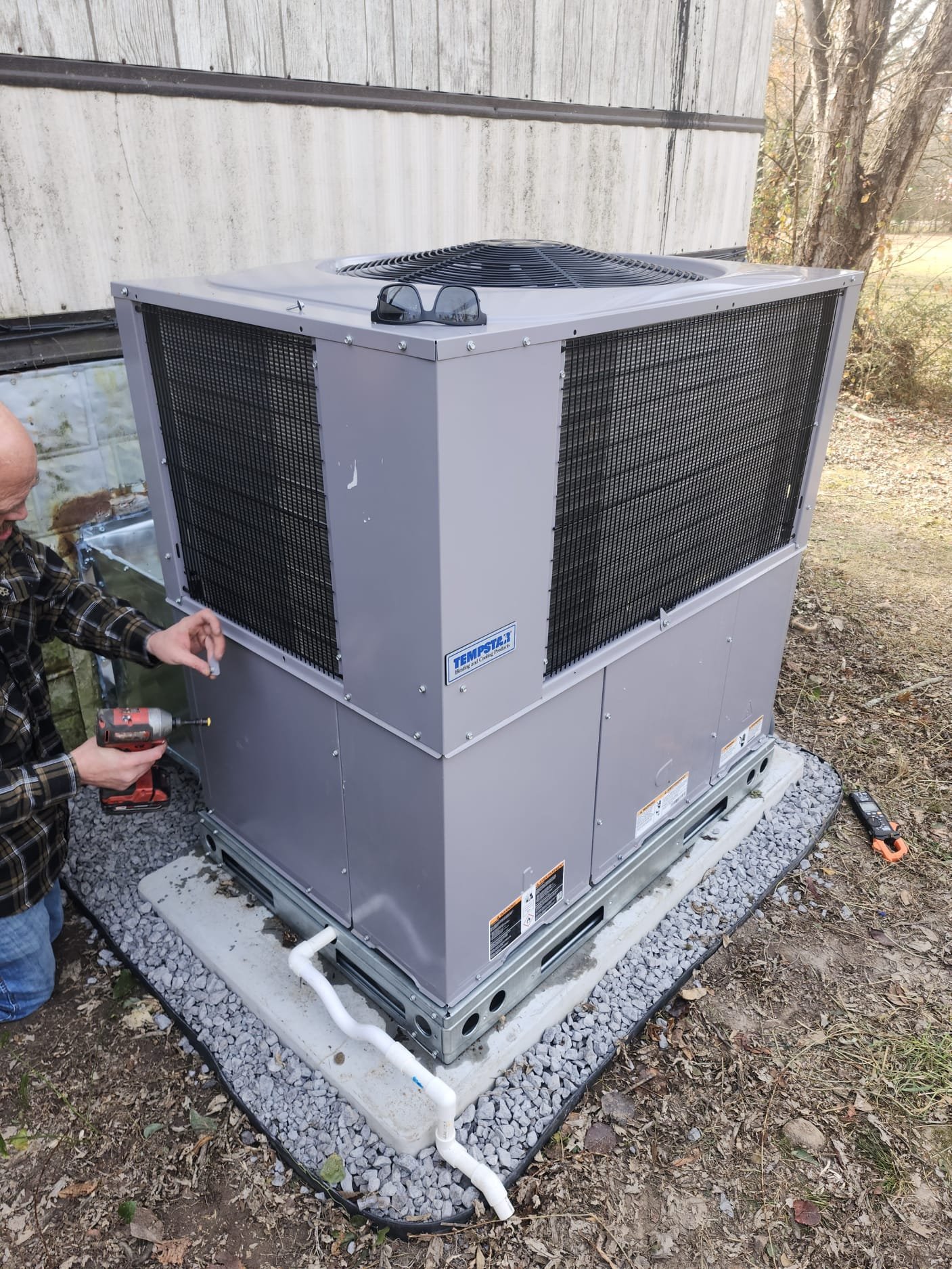Technician securing the access panel on the newly installed unit