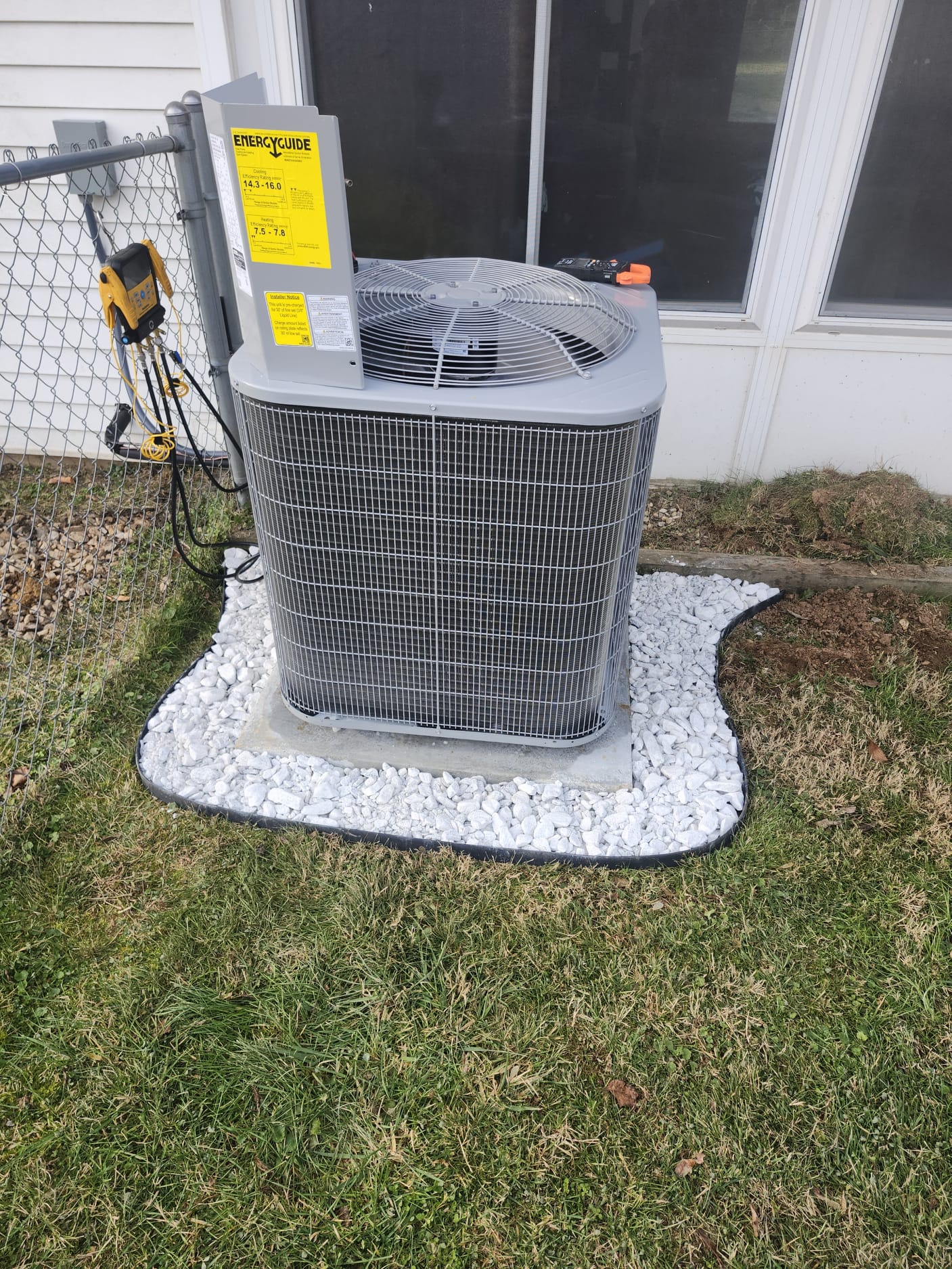 Outdoor Unit Set Up on Gravel and Energy Guide Label Visible