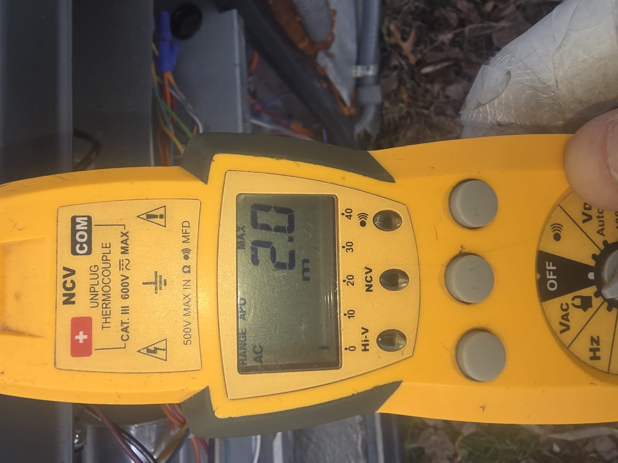 HEP technician using a digital multimeter to diagnose an HVAC system