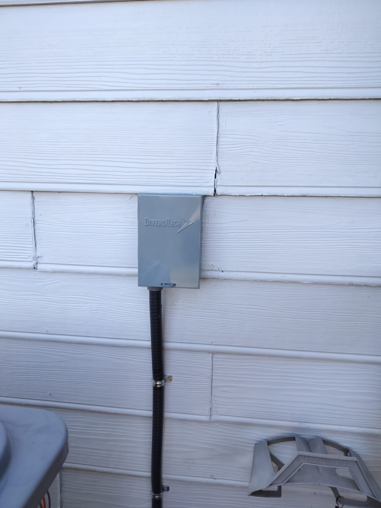 Freshly installed electrical disconnect box labeled for HVAC on the exterior wall