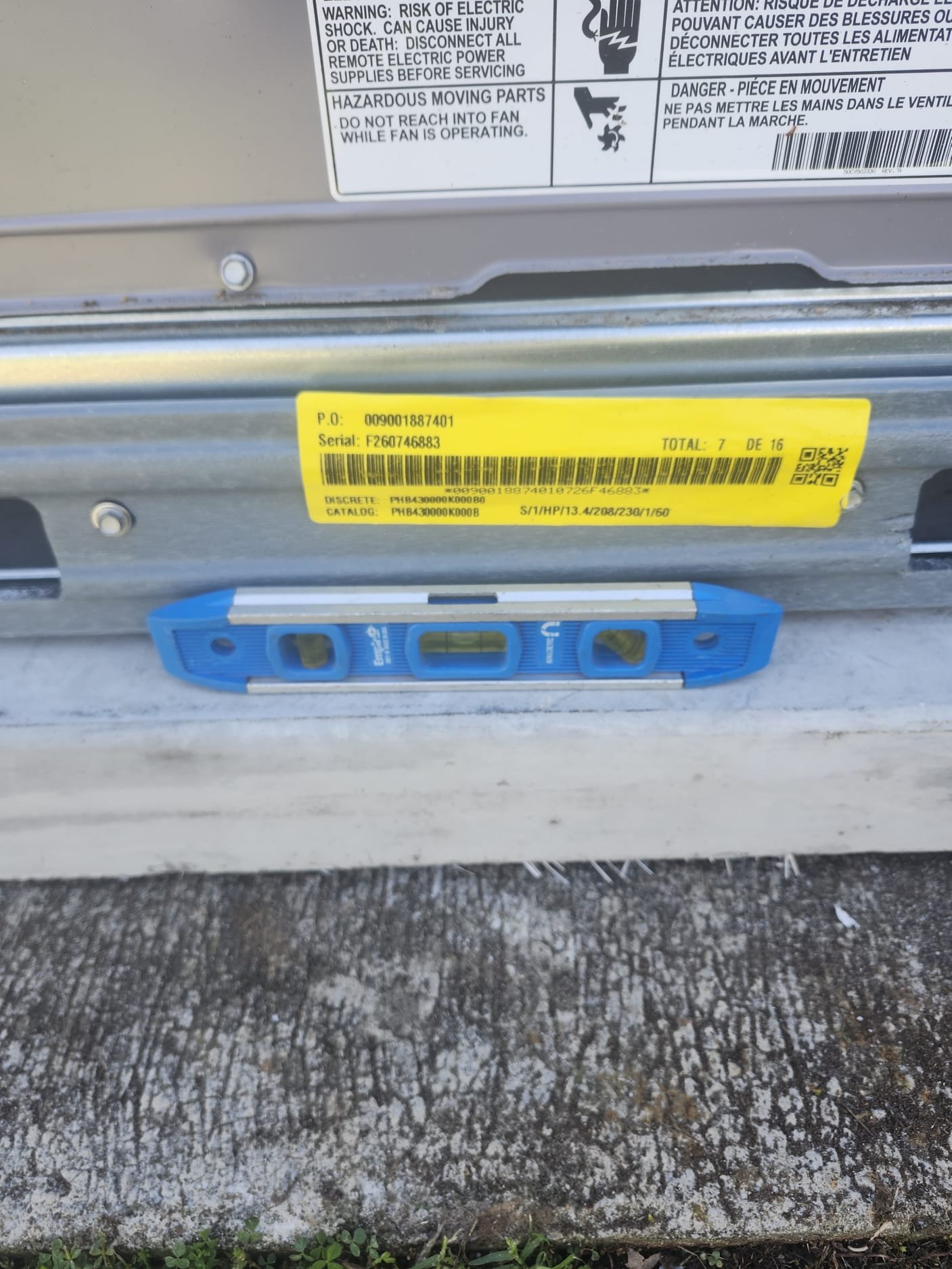 HVAC unit aligned with a blue spirit level during installation