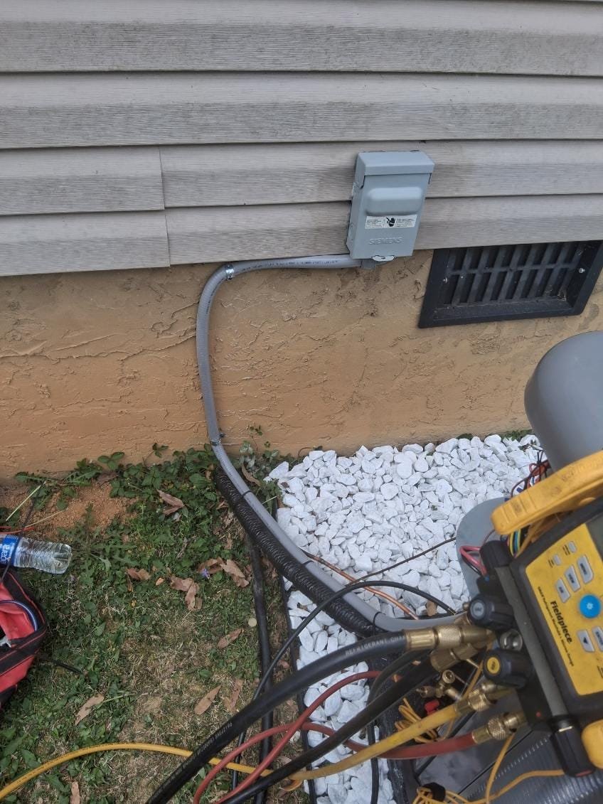 New electrical disconnect box installed next to the HVAC unit