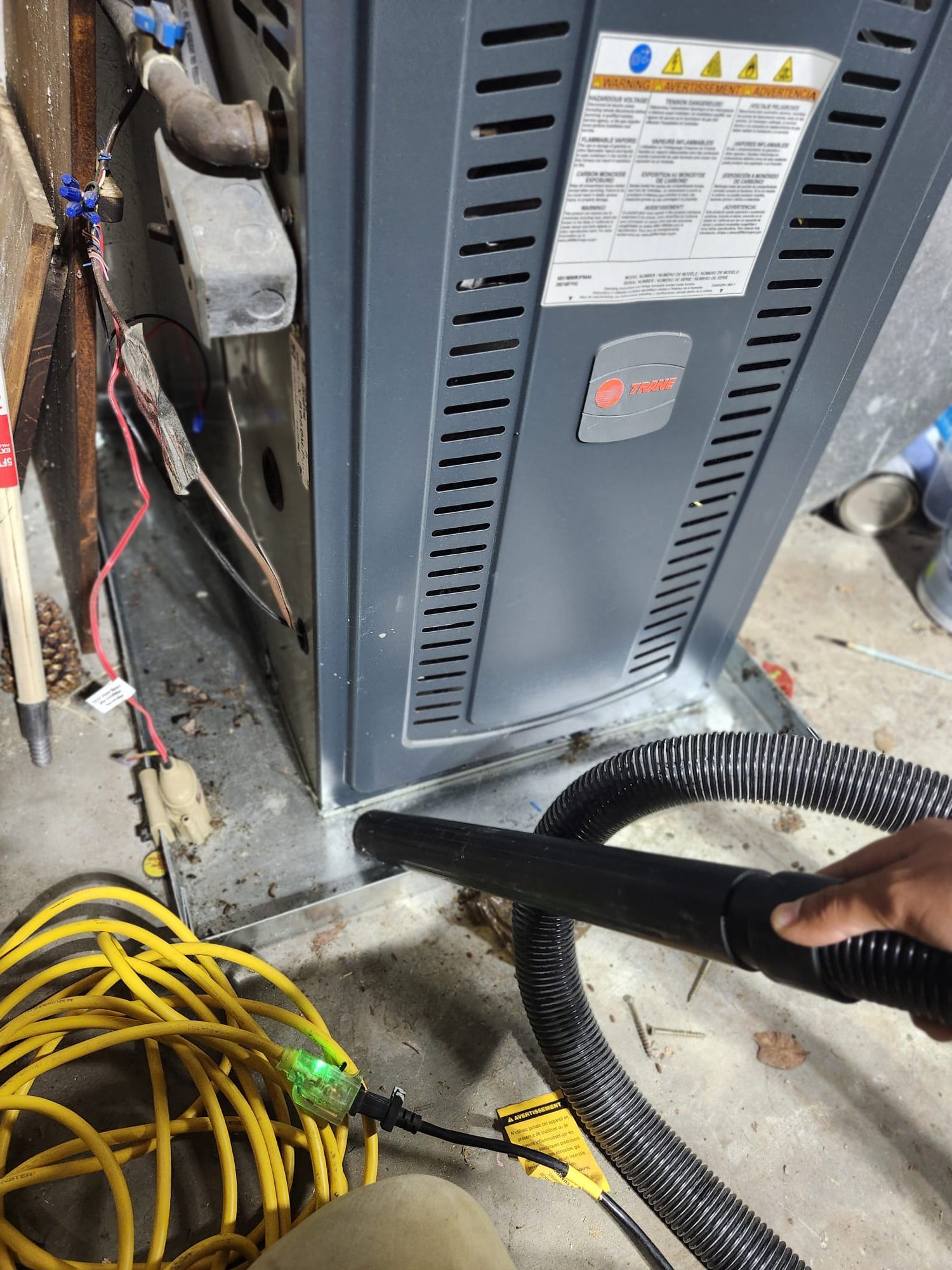 Technician Vacuuming Around Furnace