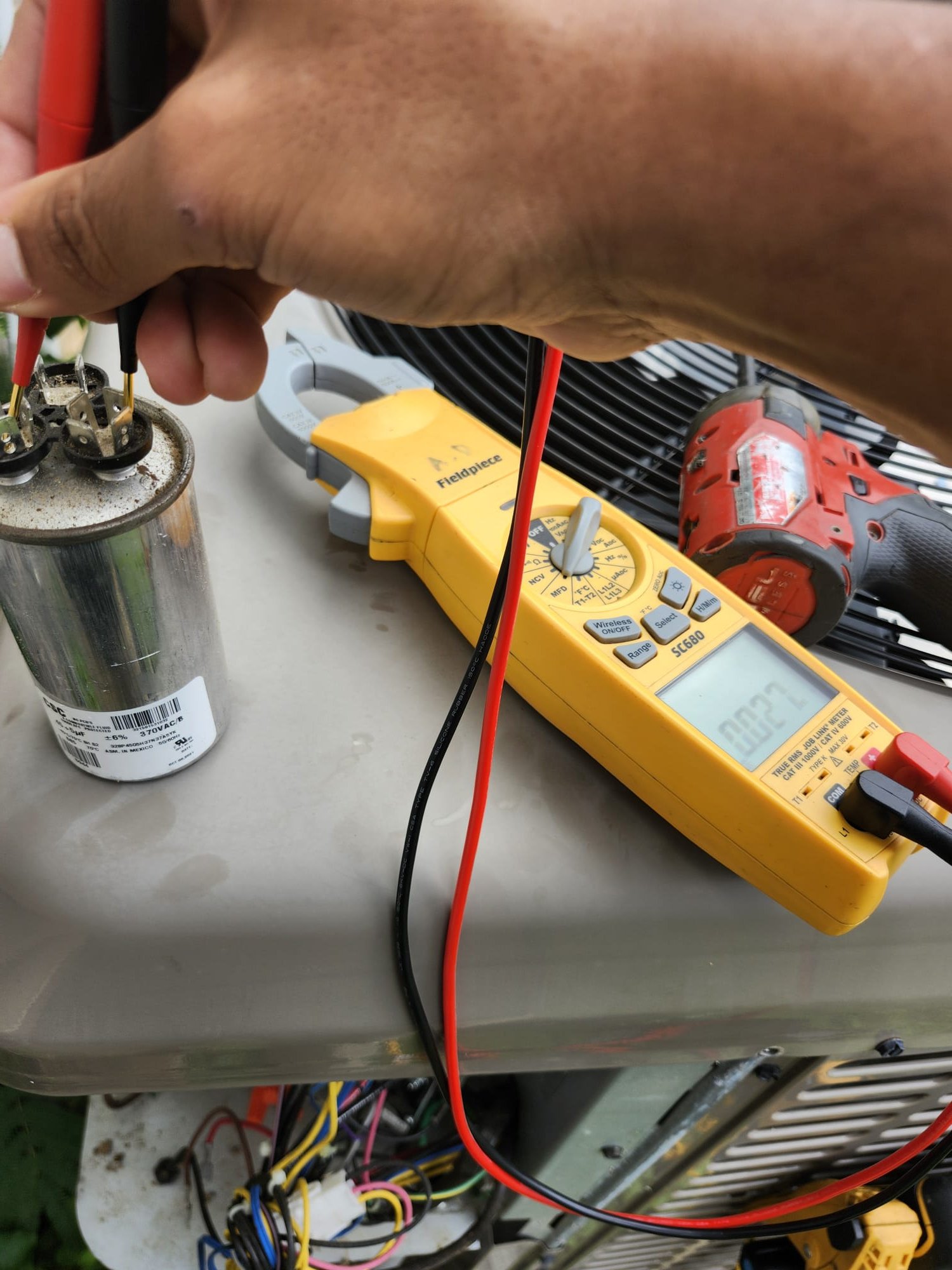 Technician checking the outdoor unit’s electrical parts