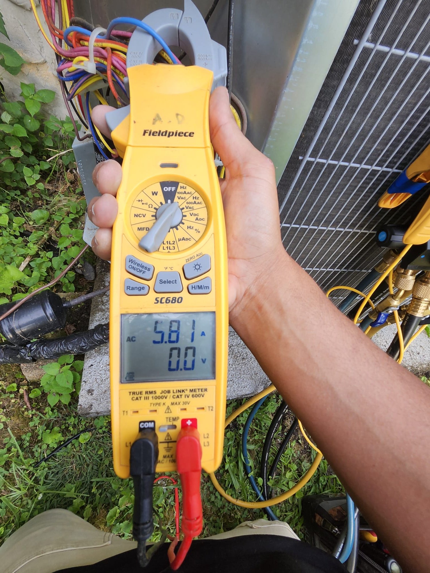 HVAC technician testing an outdoor condenser unit