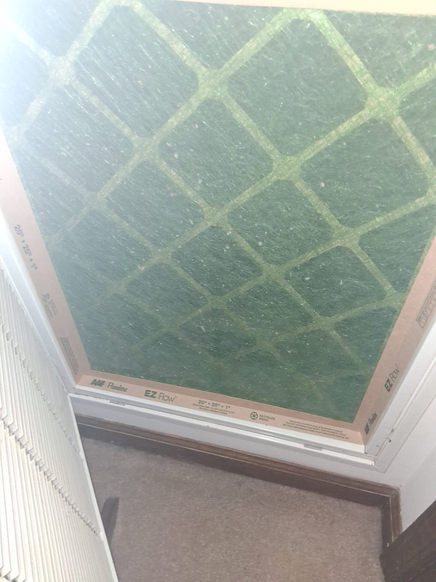 The image shows an HVAC return air filter installed in a filter grille or air handler access area.
