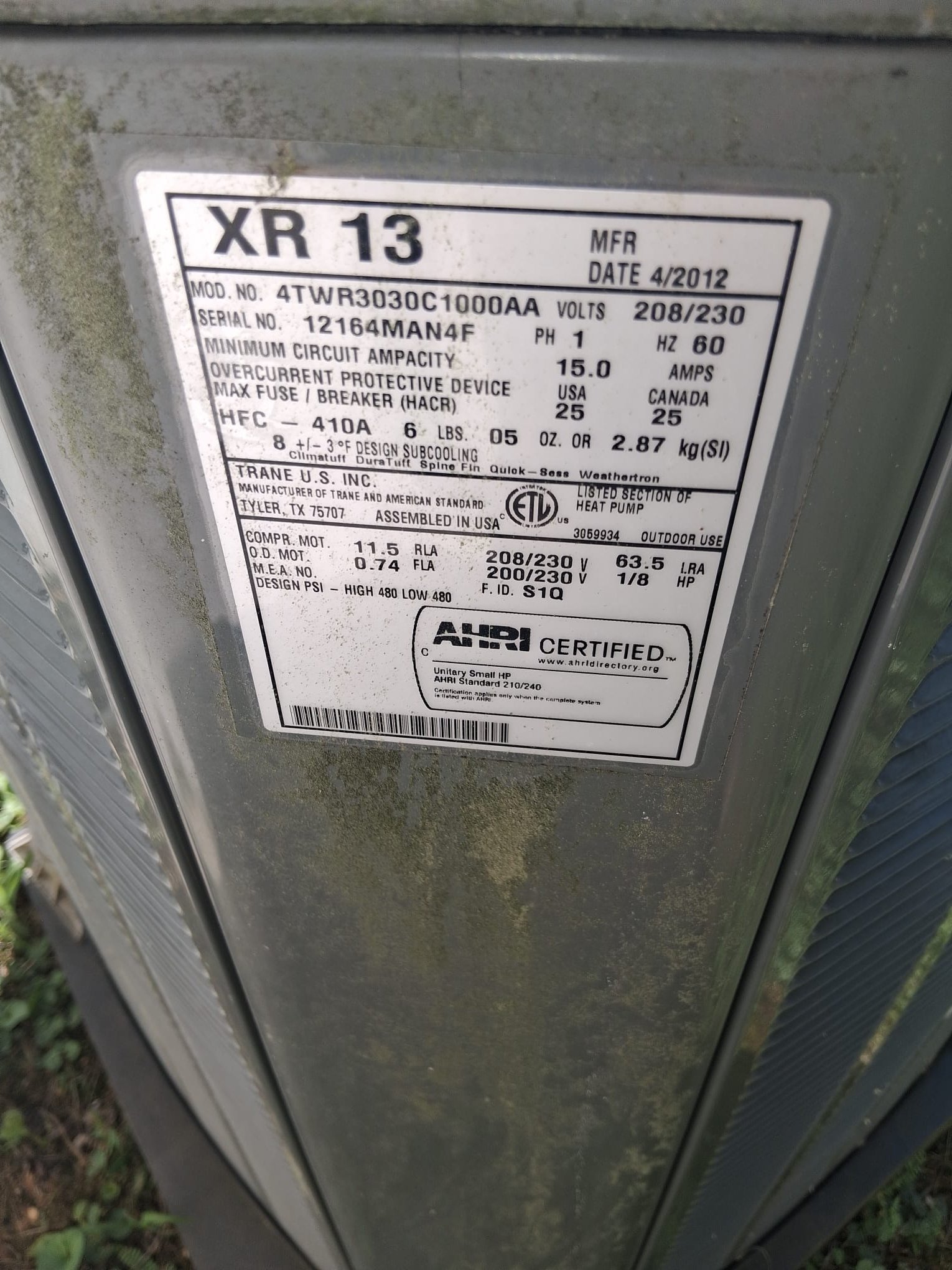 The image shows the data plate/nameplate on an outdoor HVAC heat pump condenser unit.