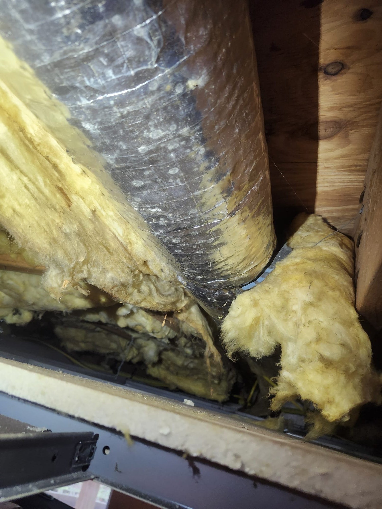 Damaged duct insulation in a crawlspace or attic area